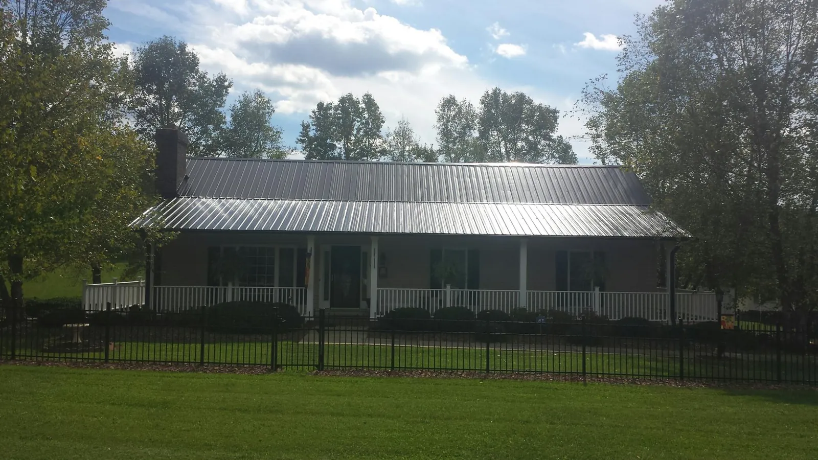 Gray metal roof on a brick ranch with a full width front porch — Gutter Guard Installation work by our crew in New Windsor